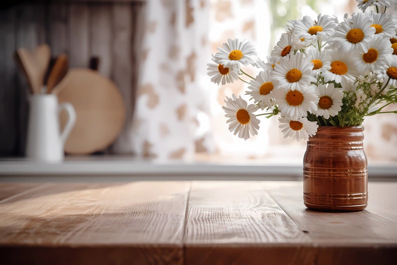 以下が含まれることがあります： 木製のテーブルの上に、茶色の陶器の花瓶に白いマーガレットの花束が飾られています。マーガレットの花はピントが合っていますが、背景はぼやけています。