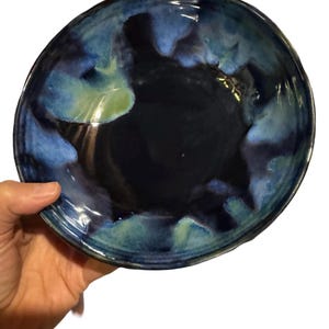 May include: A blue and green ceramic bowl with a reactive glaze. The bowl has a deep, rounded shape and a smooth, glossy finish.