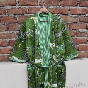 May include: Green quilted robe with a white and green striped trim. The robe features a jungle print with zebras, leopards, toucans, and palm trees. The robe has a tie belt and long sleeves.
