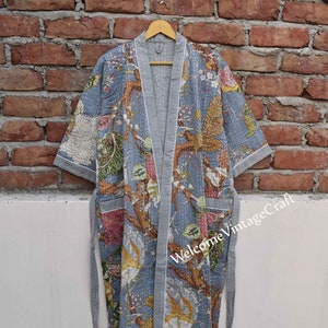 Pode incluir: Um roupão de algodão cinza com estampa floral e acabamento branco. O roupão tem um cinto para amarrar e é acolchoado. O texto "Welcome VintageCraft" é visível no roupão.