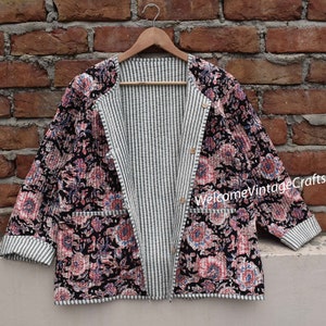May include: A reversible quilted jacket with a black and white striped pattern on one side and a floral print on the other side. The jacket has a button closure and two pockets.