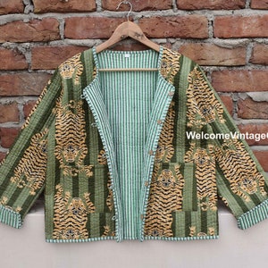 以下が含まれることがあります： 片側は緑と白のストライプ、もう片側は虎柄のリバーシブルジャケット。ボタン留めで、コットン製です。