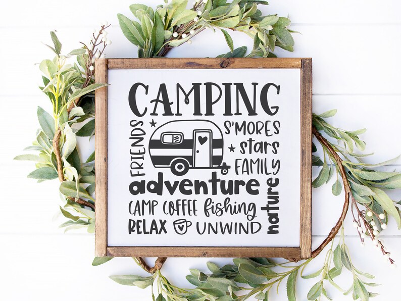 May include: A wooden sign with the text "Camping" in large letters. The sign also includes the words "friends", "adventure", "camp", "coffee", "fishing", "relax", "unwind", "s'mores", "stars", "family", and "nature". A small camper van is pictured in the center of the sign.