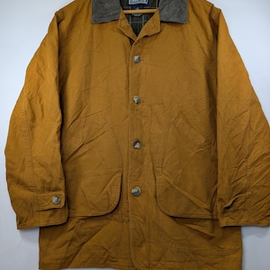May include: A mustard yellow barn jacket featuring a dark gray corduroy collar, a button-front closure, and two large front patch pockets. The interior lining displays a dark green and navy blue plaid pattern with a Lands' End brand label.