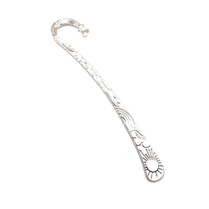 May include: Silver bookmark with a decorative design featuring a sun and clouds. The bookmark has a hook at the top for holding a page.