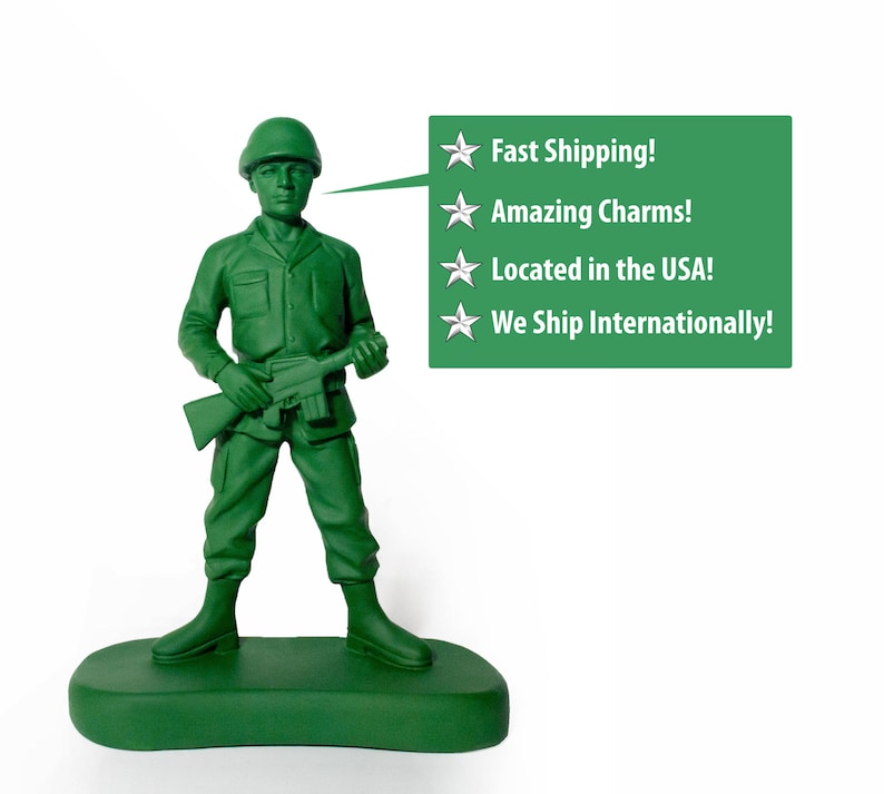 May include: A green plastic toy soldier holding a rifle, standing on a green base. The soldier is wearing a green helmet and has a green face. A speech bubble above the soldier says "Fast Shipping! Amazing Charms! Located in the USA! We Ship Internationally!"