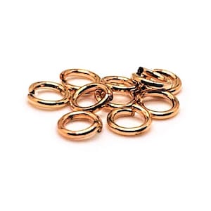 Puede incluir: Un grupo de 10 anillos de salto de oro, un tipo de hallazgo de joyería utilizado para conectar cadenas, cordones y otros componentes de joyería.