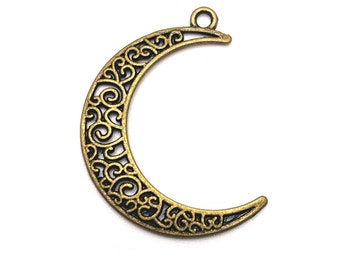May include: A gold-toned metal crescent moon charm with an intricate filigree design. The charm has a loop at the top for attaching to jewelry or other crafts.