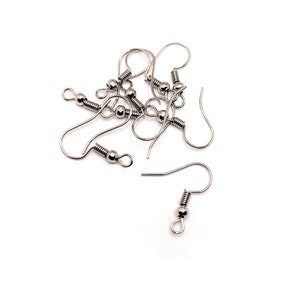 May include: A close-up of a pile of silver-toned earring hooks. The hooks are made of metal and have a spring-loaded closure. They are designed for use with jewelry making.