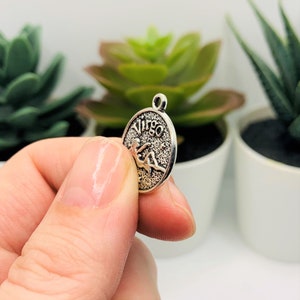 Op de afbeelding: Zilveren bedel met het astrologische teken Maagd en het woord "Maagd" erop gegraveerd.