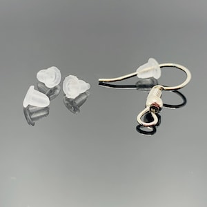 May include: Four clear silicone earring backs and a silver earring hook with a spring closure.