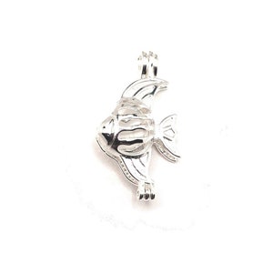 Op de afbeelding: Zilveren visvormige bedel met een kooi-achtig ontwerp. De bedel is aan één kant open en heeft een lus aan de bovenkant om aan een ketting of armband te bevestigen.
