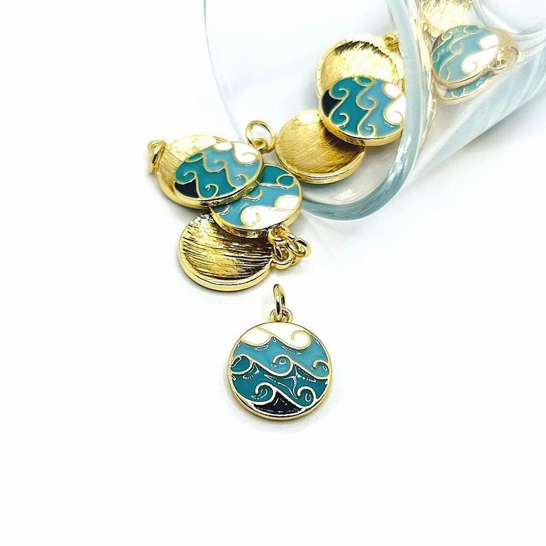 May include: Gold-tone metal charms with a blue and white enamel design. The charms feature a wave pattern and are perfect for jewelry making.