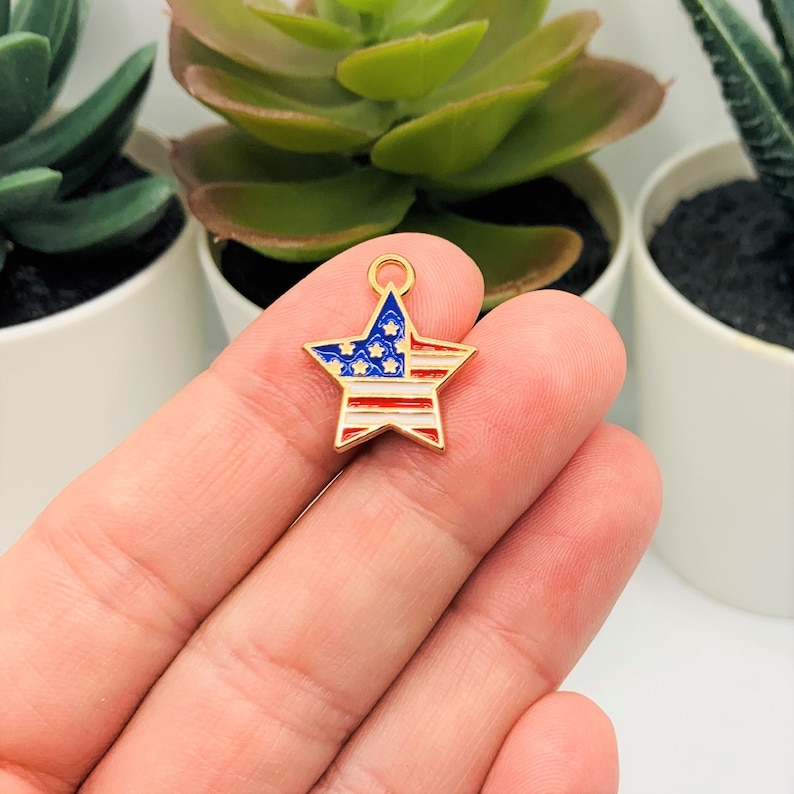 May include: Gold star charm with an enamel American flag design. The star is red, white, and blue.