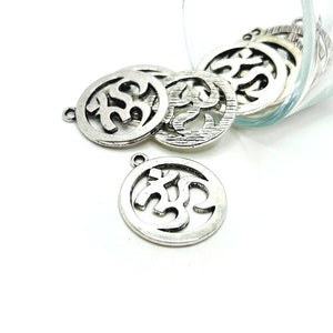 May include: Silver metal charms with an Om symbol design. The charms are round and have a hole at the top for attaching to jewelry or other crafts.