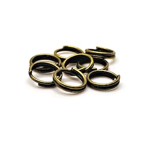以下が含まれることがあります： 金色のジャンプリング、別名スプリットリングと呼ばれる10個のリングが積み重ねられています。これらのリングは、チャーム、ペンダント、またはその他のジュエリー部品を取り付けるために使用されます。