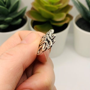 May include: Silver-toned metal charm in the shape of a stylized octopus with tentacles.