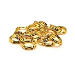 May include: A pile of 12 gold jump rings, each with a double-loop design. These rings are perfect for jewelry making, crafting, and other DIY projects.