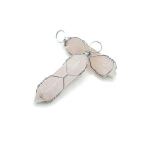 May include: Two pink rose quartz crystal points wrapped in silver wire, forming a pendant.