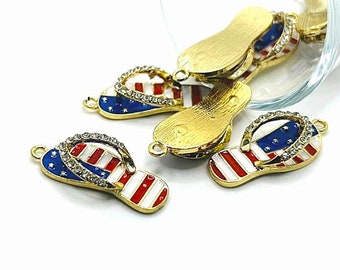 May include: Gold-tone flip flop charms with red, white, and blue enamel and rhinestones. The charms are shaped like flip flops and have the American flag design.