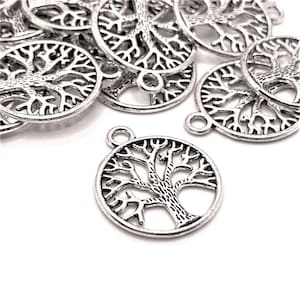 May include: A group of silver-toned metal charms in the shape of a tree of life. The charms have a detailed design and a loop for attaching to jewelry or other crafts.