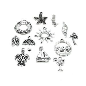 May include: A selection of silver-coloured charms with a seaside theme. The charms include a starfish, seashell, mermaid, sun, sailboat, turtle, flip-flops, umbrella, life ring, waves, palm tree, and a margarita glass.