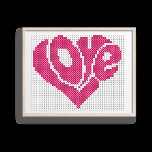 May include: A pink cross-stitch design in the shape of a heart with the word "LOVE" stitched inside.