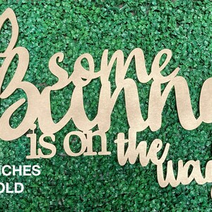 May include: Gold wooden sign with the text "Some bunny is on the way" in a cursive font. The sign is 36 inches long.