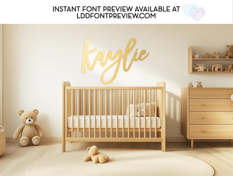 May include: A nursery scene with a wooden crib, dresser, and shelves. A gold-colored name, "Kaylie", is mounted on the wall. The room is decorated with teddy bears and a round rug. Text at the top reads "INSTANT FONT PREVIEW AVAILABLE AT LDDFONTPREVIEW.COM".