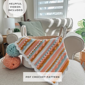 May include: A crochet project with a colorful, striped pattern in a basket. The project features peach, white, blue, and mustard yellow yarn. The text "Helpful Videos Included" and "PDF Crochet Pattern" are visible.