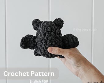 May include: Crochet pattern for a black amigurumi octopus. The pattern is available as an English PDF download. The text "Crochet Pattern" and "English PDF" is visible in the image.