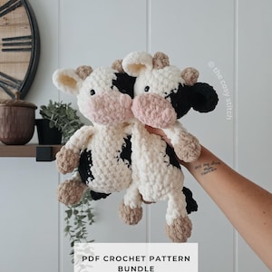 May include: Two plush cow toys made of white, black, and tan yarn with pink muzzles and black eyes. The toys feature a soft, chunky texture. Text on the image reads: the cosy stitch and PDF CROCHET PATTERN BUNDLE.