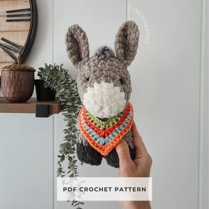 May include: A set of three ceramic mugs with a speckled, matte finish. The mugs are in shades of cream, light gray, and dark gray. Each mug has a simple, minimalist design and a rounded handle.