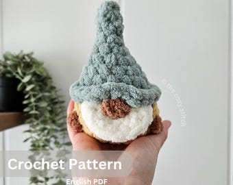 Pode incluir: Padrão de crochê para um gnomo com um chapéu verde, barba marrom e rosto branco. O padrão está disponível em formato PDF em inglês.