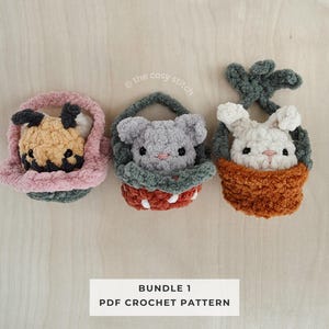May include: Three handmade crochet animal baskets: a dog, a mouse, and a bunny. The dog is in a pink basket, the mouse in a green and red basket, and the bunny in an orange basket. The text "BUNDLE 1 PDF CROCHET PATTERN" is below the baskets.