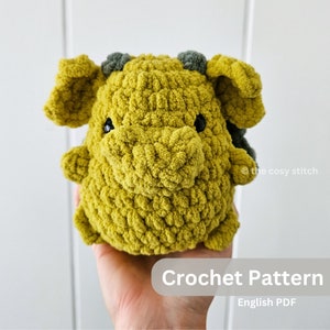 Op de afbeelding: Haakpatroon voor een groen en grijs pluche drakenknuffel. Het patroon is beschikbaar als een Engelse PDF-download.  @the cosy stitch
