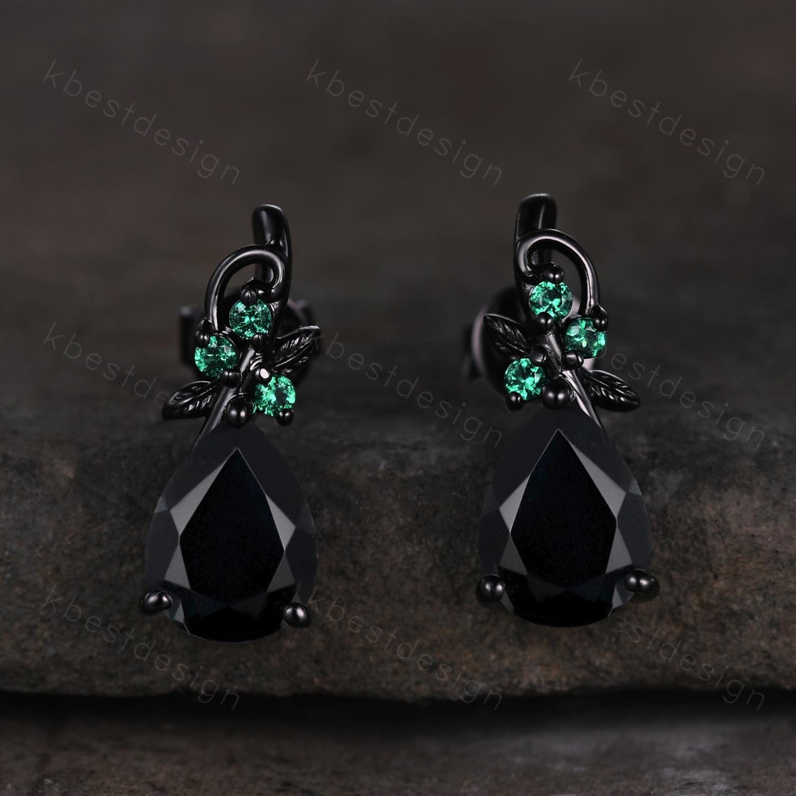 Black onyx and emerald teardrop goth earrings on dark stone background