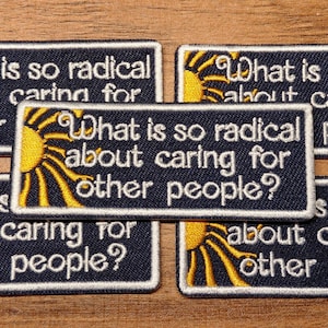 May include: Embroidered patches with the text "What is so radical about caring for other people?" in white on a navy blue background. Each patch features a yellow sun design. Patches are rectangular.