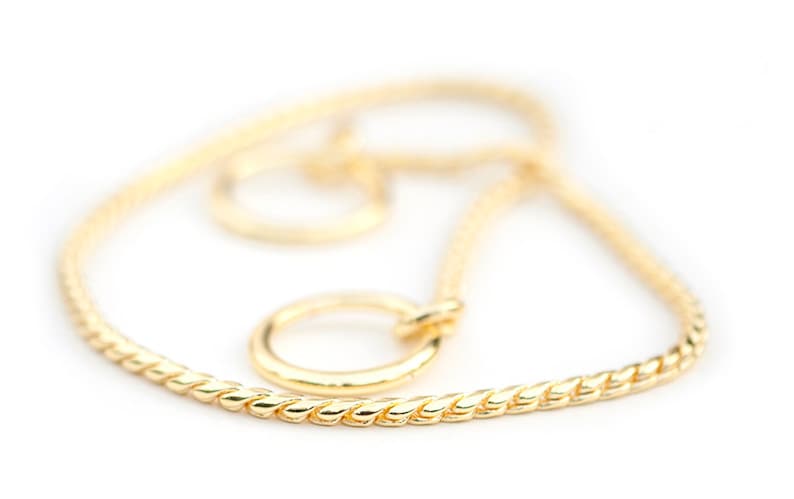 May include: A gold chain necklace with a twisted rope design. The chain has a small, round, gold clasp.