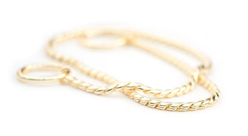 May include: A gold chain necklace with a twisted rope design. The chain is made of a thick, durable metal and has a polished finish.
