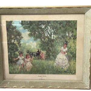 May include: Framed vintage print depicting a pastoral scene with figures in a lush green landscape. The artwork features a woman in a white dress, children, and a horse-drawn carriage. The frame is gold-toned with a textured edge.