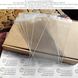 Puede incluir: Bolsas transparentes de almid&oacute;n vegetal biodegradable apiladas dentro de una caja de cart&oacute;n reciclado. Las pegatinas indican: "Esta bolsa est&aacute; hecha de almid&oacute;n vegetal compostable y biodegradable."