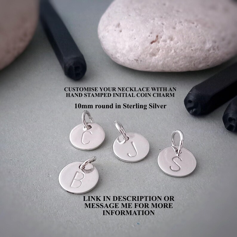 Puede incluir: Encantos de monedas iniciales de plata de ley, cada uno de 10 mm de di&aacute;metro, con letras B, C, J y S estampadas a mano. Los amuletos est&aacute;n dise&ntilde;ados para agregarse a un collar. La imagen incluye texto que dice "CUSTOMISE YOUR NECKLACE WITH AN HAND STAMPED INITIAL COIN CHARM".