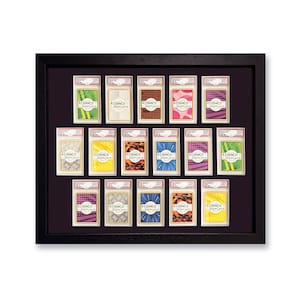 May include: A black framed display case holding 15 trading card holders. Each holder has a different patterned background and the text "RIDANCO DISPLAYS". The cards are arranged in a grid on a dark purple background.