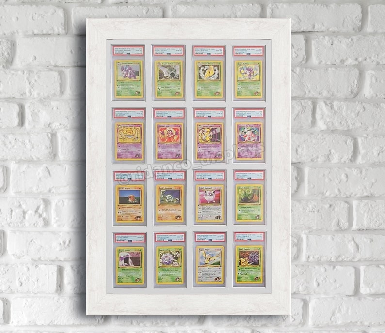 May include: A white frame with 16 clear plastic sleeves holding Pokemon trading cards. The cards feature various Pokemon characters, including Pikachu, Charizard, and Bulbasaur.