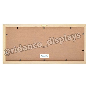 Op de afbeelding: De achterkant van een houten fotolijst met een bruine kartonnen achterkant. De lijst heeft een kleine metalen ophanghaak en de tekst "@ridanco_displays" en "Ridanco Displays" gedrukt op de achterkant.