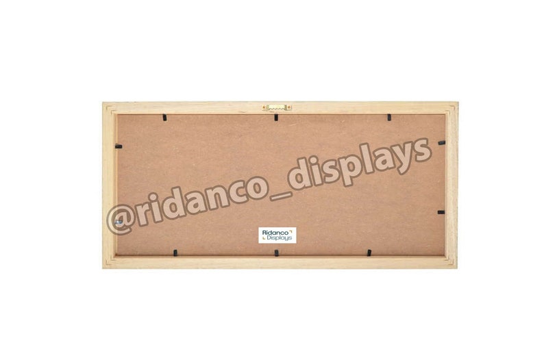 Op de afbeelding: De achterkant van een houten fotolijst met een bruine kartonnen achterkant. De lijst heeft een kleine metalen ophanghaak en de tekst "@ridanco_displays" en "Ridanco Displays" gedrukt op de achterkant.