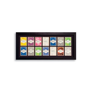 May include: A black framed display case holding 15 small cards with colorful designs. Each card has the text "REDANCO DISPLAYS" printed on it. The cards have various patterns and colors, including yellow, purple, and blue.