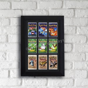 May include: A framed collection of twelve Pokémon trading card packs. The packs are arranged in a grid within a black frame, showcasing various Pokémon characters and the "Pokémon" logo. The background is a white brick wall.