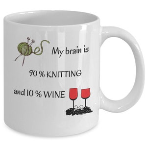 Puede incluir: Taza de cerámica blanca con una ilustración en negro y verde de agujas de tejer e hilo. El texto dice "Mi cerebro es 90% tejido y 10% vino". Dos copas de vino tinto con uvas se ilustran debajo del texto.
